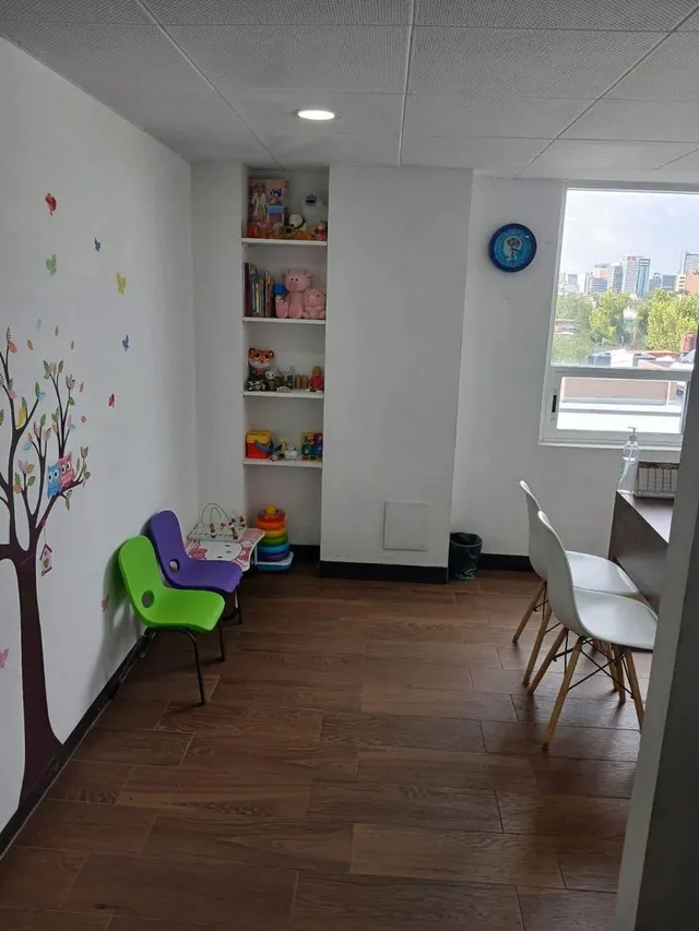 Rincón infantil con juguetes y sillas de colores en el consultorio